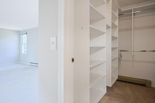 spacious closet featuring baseboard heating and carpet