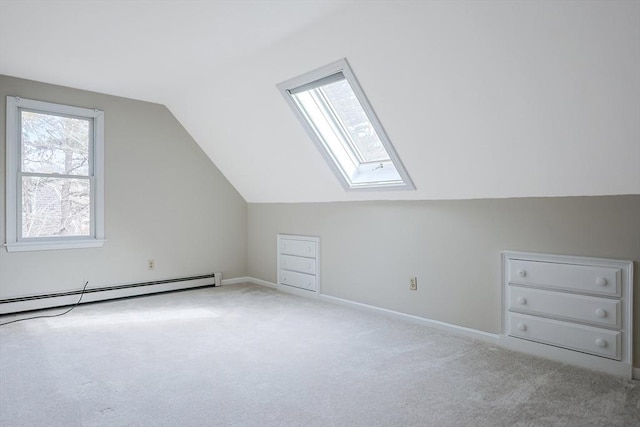 additional living space with a baseboard radiator, lofted ceiling with skylight, baseboards, and carpet flooring