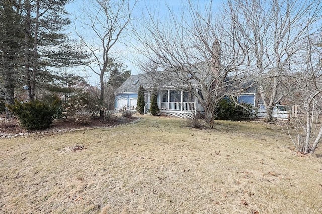 view of front of property featuring a porch, an attached garage, and a front lawn