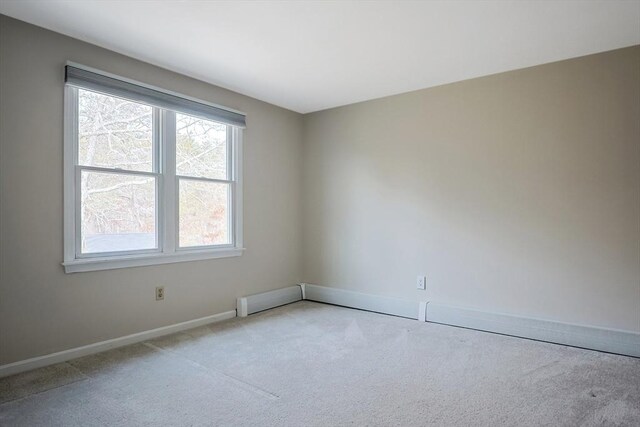 carpeted empty room with baseboards