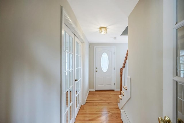 doorway to outside featuring french doors, baseboards, stairs, and light wood-style floors