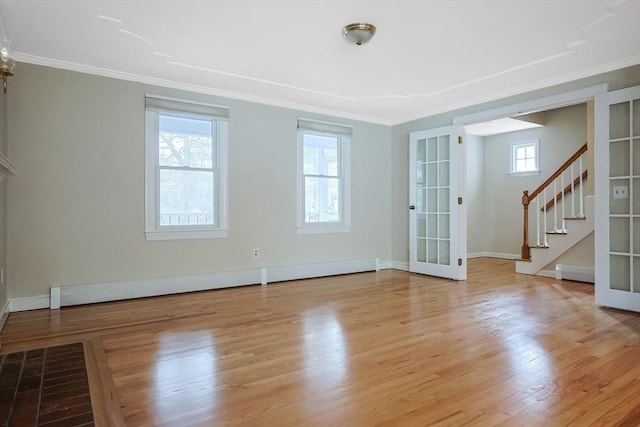 unfurnished living room featuring stairway, wood finished floors, and ornamental molding