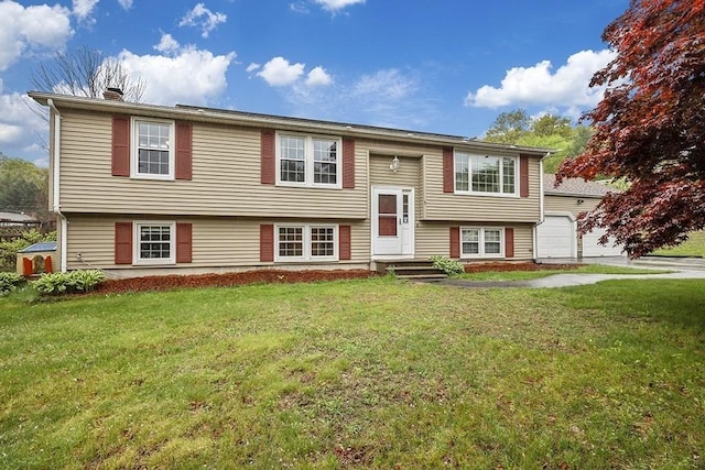 raised ranch with a front yard, a garage, and a chimney