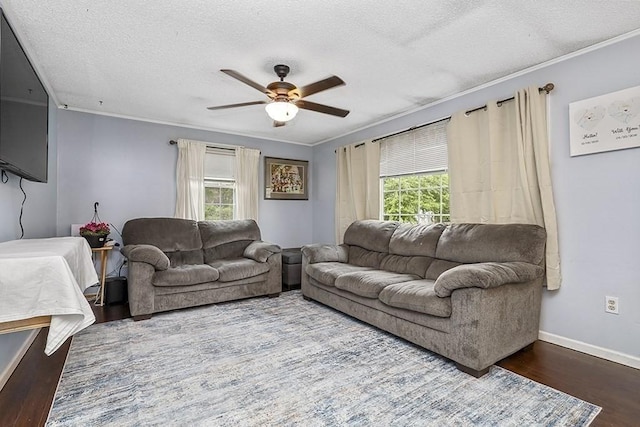 living room featuring healthy amount of natural light, ceiling fan, wood finished floors, ornamental molding, and a textured ceiling