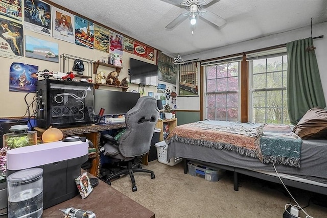 carpeted bedroom featuring a textured ceiling, an office area, and a ceiling fan