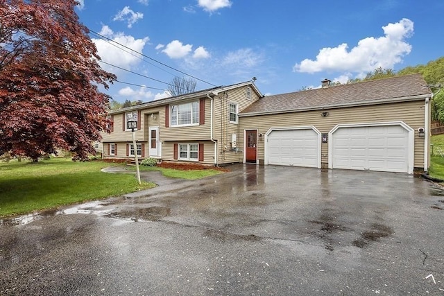 split foyer home featuring driveway, an attached garage, a front yard, and a chimney