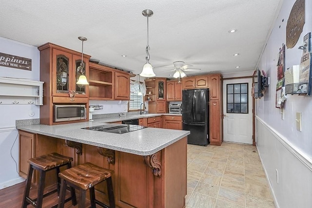 kitchen with black appliances, open shelves, a peninsula, brown cabinets, and a ceiling fan