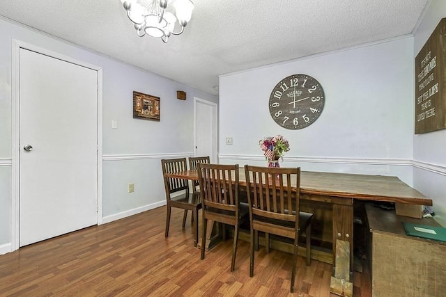 dining room featuring wood finished floors, a textured ceiling, and a chandelier