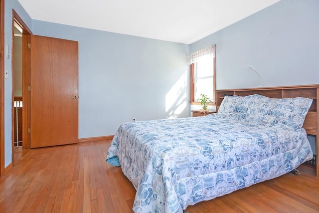 bedroom with baseboards and wood finished floors