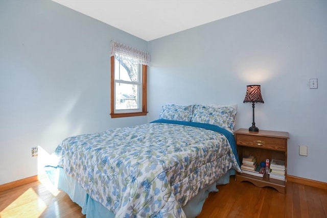 bedroom with baseboards and wood finished floors