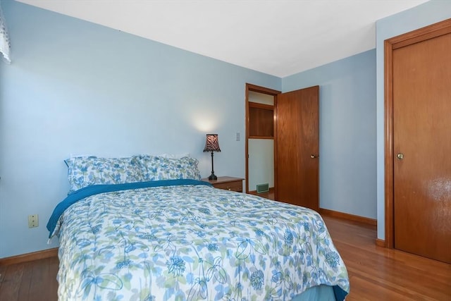 bedroom featuring wood finished floors and baseboards