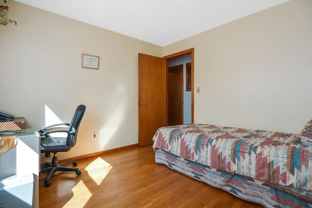 bedroom featuring baseboards and wood finished floors