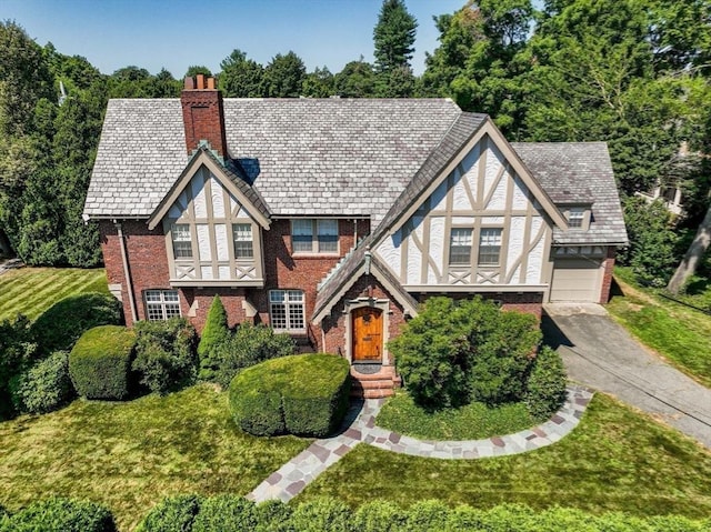 english style home with a garage and a front yard