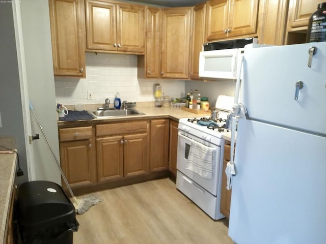 kitchen featuring sink, white appliances, light hardwood / wood-style flooring, and backsplash