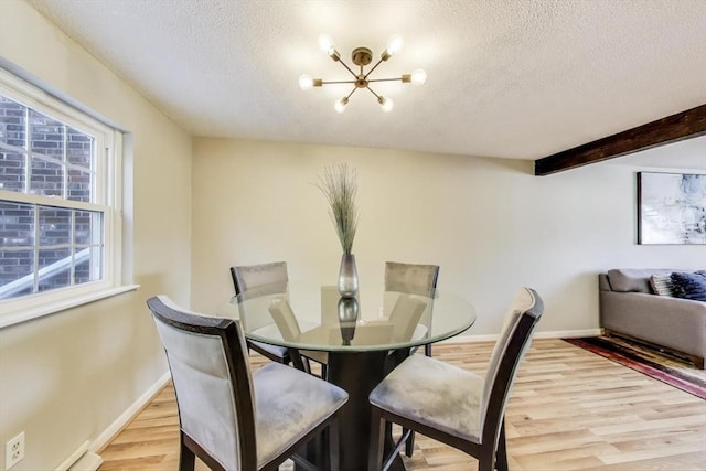 dining area featuring beamed ceiling, a chandelier, light hardwood / wood-style floors, and a textured ceiling