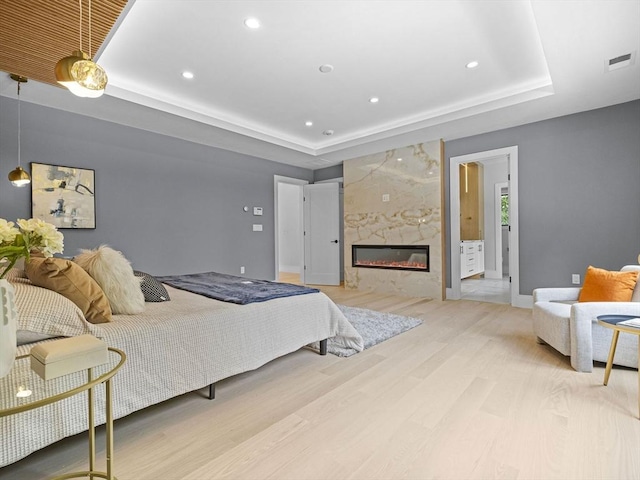 bedroom featuring light hardwood / wood-style floors and a fireplace