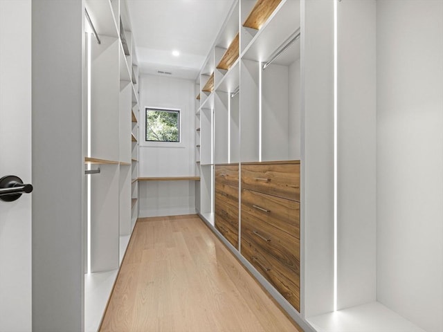 walk in closet with hardwood / wood-style flooring