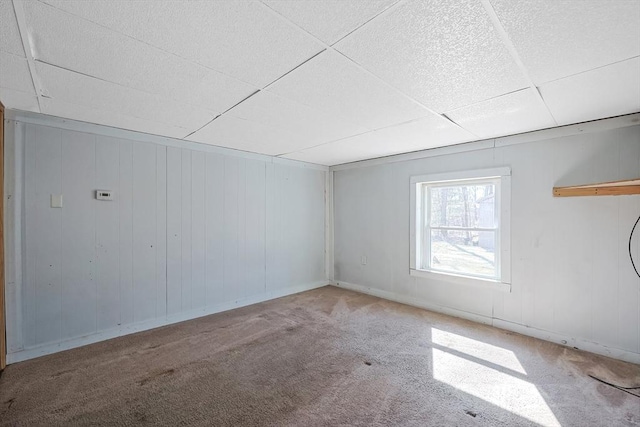 interior space featuring baseboards, a paneled ceiling, and carpet