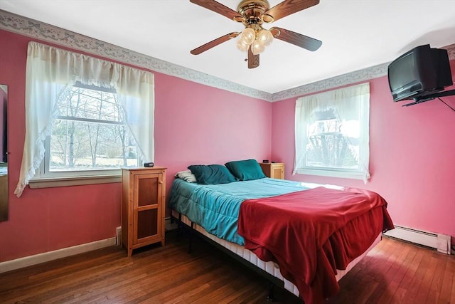 bedroom with baseboard heating, ceiling fan, baseboards, and hardwood / wood-style flooring