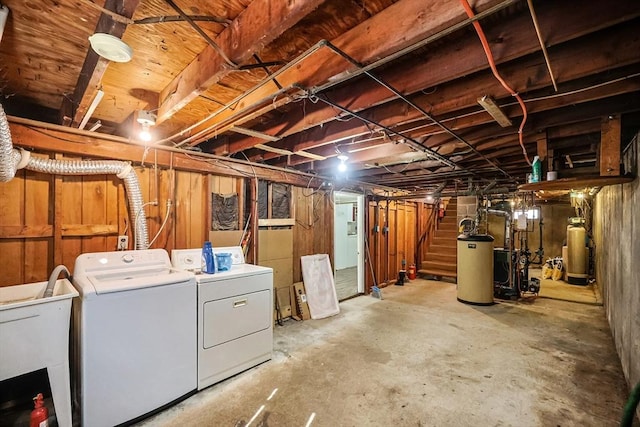 unfinished below grade area with stairs, gas water heater, a sink, and washer and clothes dryer