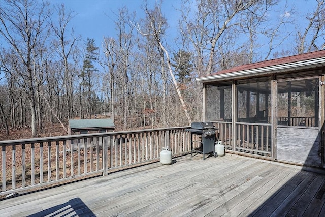 wooden deck with a grill and a sunroom