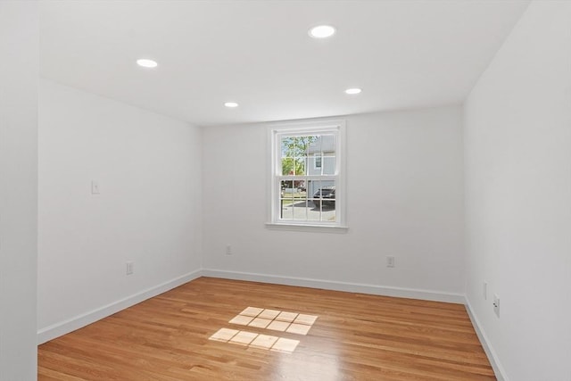 spare room with light wood-style floors, baseboards, and recessed lighting