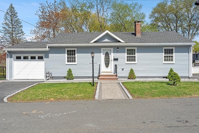 single story home featuring a chimney, roof with shingles, aphalt driveway, an attached garage, and a front lawn