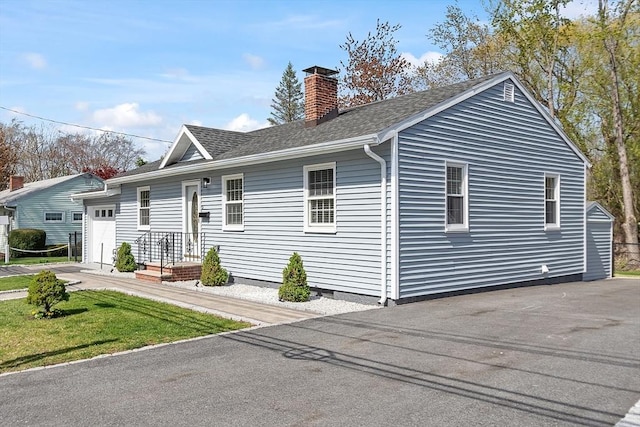 view of property exterior featuring a shingled roof and a chimney