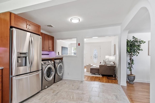washroom featuring separate washer and dryer, baseboards, and visible vents