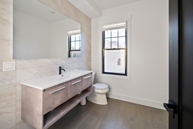 bathroom with vanity, tile walls, and toilet