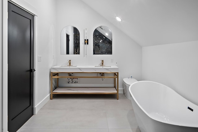 bathroom featuring a washtub, tile patterned flooring, vaulted ceiling, toilet, and vanity