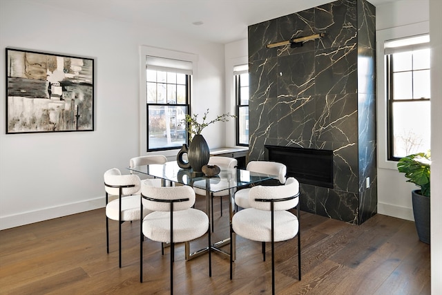 dining space featuring a fireplace and dark hardwood / wood-style flooring