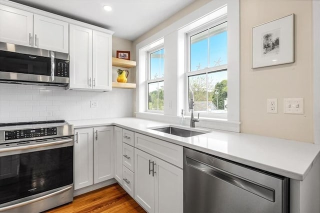 6 Macdonald Ter Unit E, Scituate, MA 02066 - kitchen featuring appliances with stainless steel finishes, a sink, tasteful backsplash, light countertops, and white cabinetry
