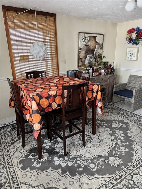 dining room with tile patterned flooring and a textured ceiling