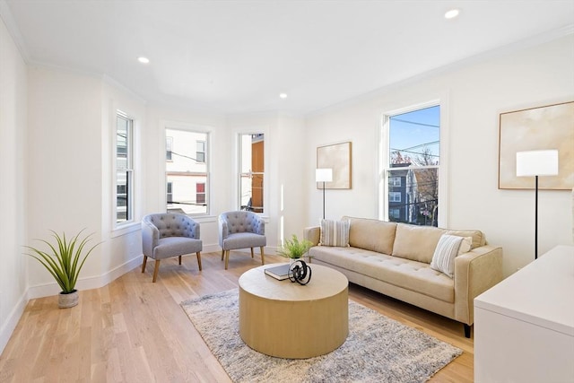 living room with a wealth of natural light, ornamental molding, and light wood-type flooring