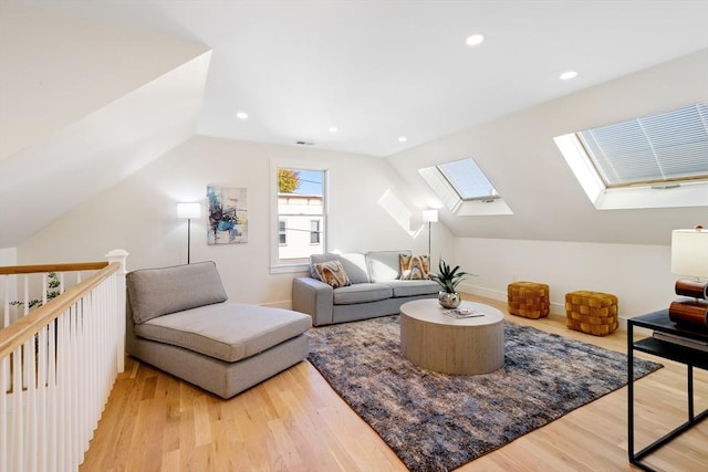 interior space featuring lofted ceiling with skylight and light wood-type flooring