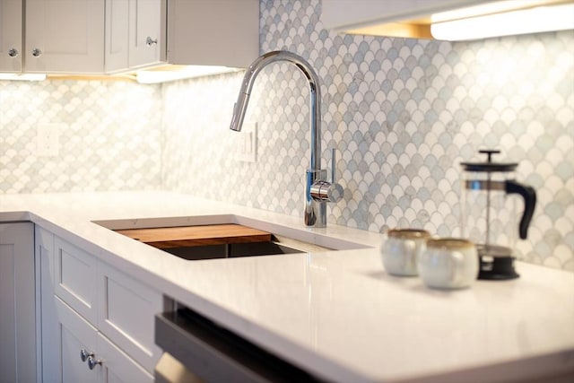 kitchen with white cabinetry, sink, and decorative backsplash