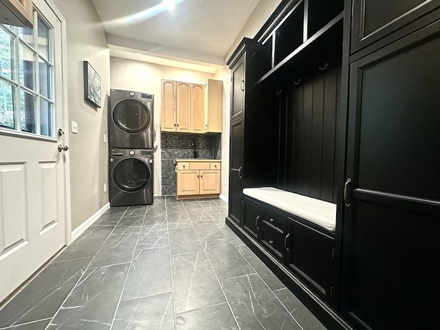 104 Channing Rd, Concord, MA 01742 - mudroom featuring stacked washer and clothes dryer, marble look tiles, and baseboards