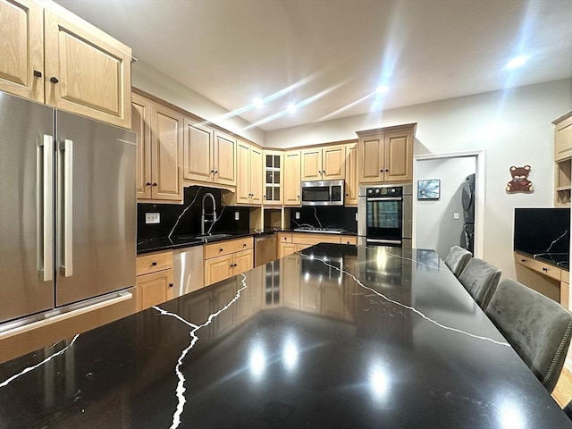 104 Channing Rd, Concord, MA 01742 - kitchen with stainless steel appliances, stacked washer and clothes dryer, dark countertops, and light brown cabinets