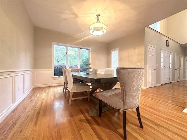 104 Channing Rd, Concord, MA 01742 - dining room featuring light wood-type flooring, a wainscoted wall, and a chandelier