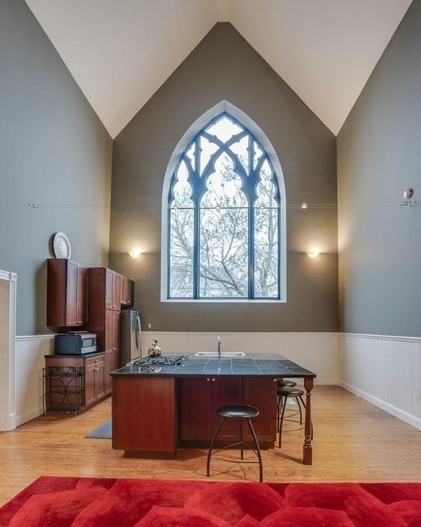 kitchen featuring light wood-type flooring, beam ceiling, and high vaulted ceiling