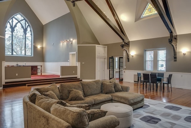 living room with wood-type flooring, beam ceiling, and high vaulted ceiling