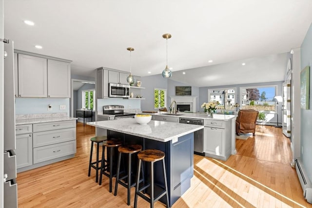 6 Riverview Dr, Newburyport, MA 01950 - kitchen featuring stainless steel appliances, a peninsula, a baseboard heating unit, light wood finished floors, and recessed lighting