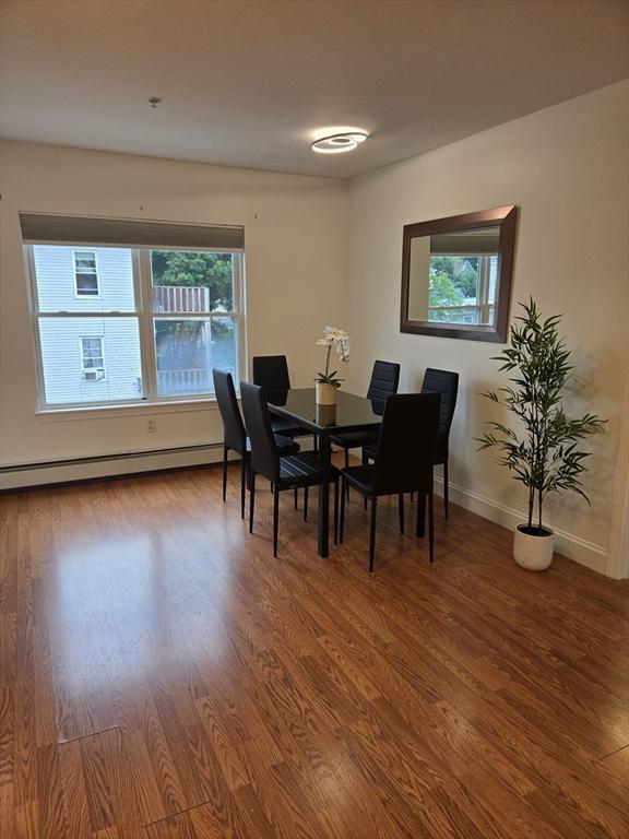 315 Cambridge St Unit 302A, Worcester, MA 01603 - dining space featuring baseboard heating, healthy amount of natural light, and wood finished floors