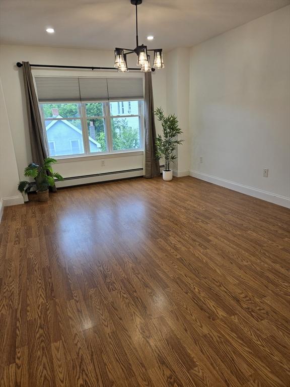 315 Cambridge St Unit 302A, Worcester, MA 01603 - empty room featuring a baseboard heating unit, wood finished floors, a chandelier, and recessed lighting