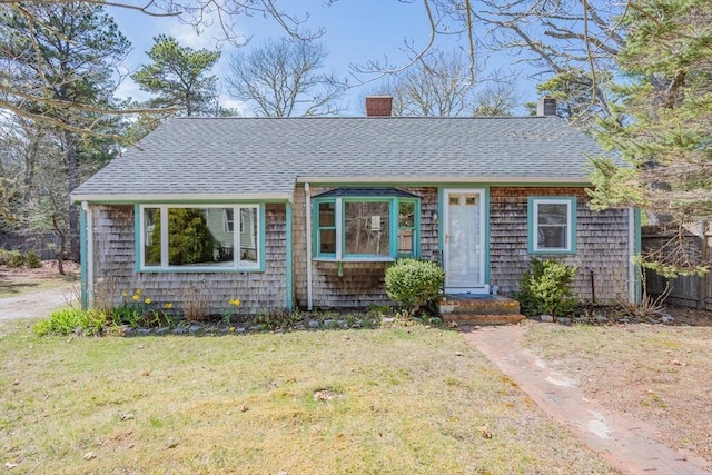 25 Charlotte Ave, Barnstable, MA 02635 - view of front facade featuring fence, roof with shingles, a chimney, and a front lawn