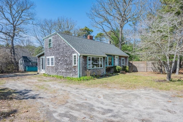 25 Charlotte Ave, Barnstable, MA 02635 - exterior space featuring fence, a front yard, roof with shingles, and a chimney