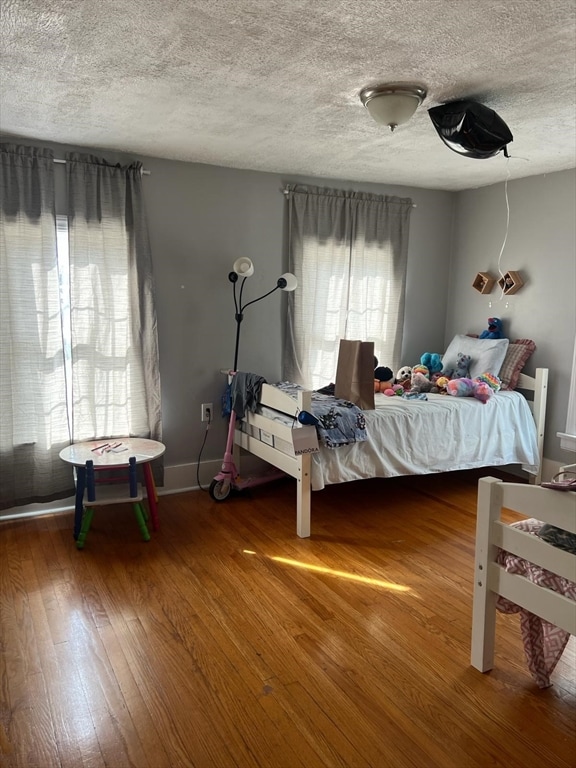 bedroom with dark wood-type flooring and a textured ceiling