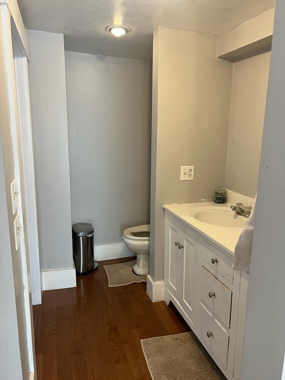 bathroom featuring vanity, toilet, and hardwood / wood-style floors