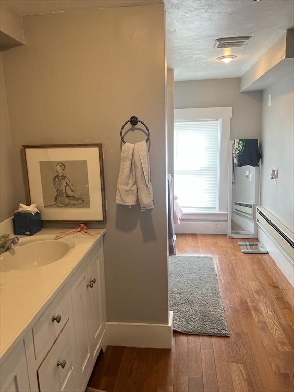 bathroom with vanity, a textured ceiling, and hardwood / wood-style floors